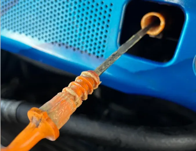 Milky engine oil on a dipstick indicating a blown head gasket and coolant mixture.