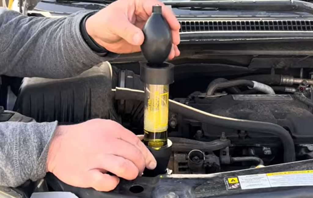 Using a head gasket test kit to extract air from a radiator for chemical analysis.