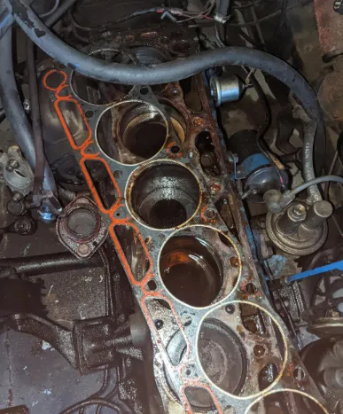Old, cracked, and brittle rubber from a failed valve cover gasket showing extreme thermal damage.