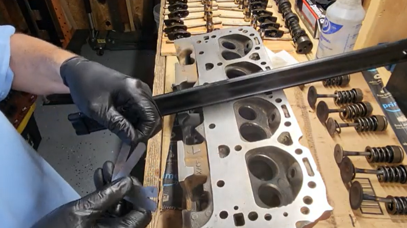Checking cylinder head flatness during a head gasket replacement.