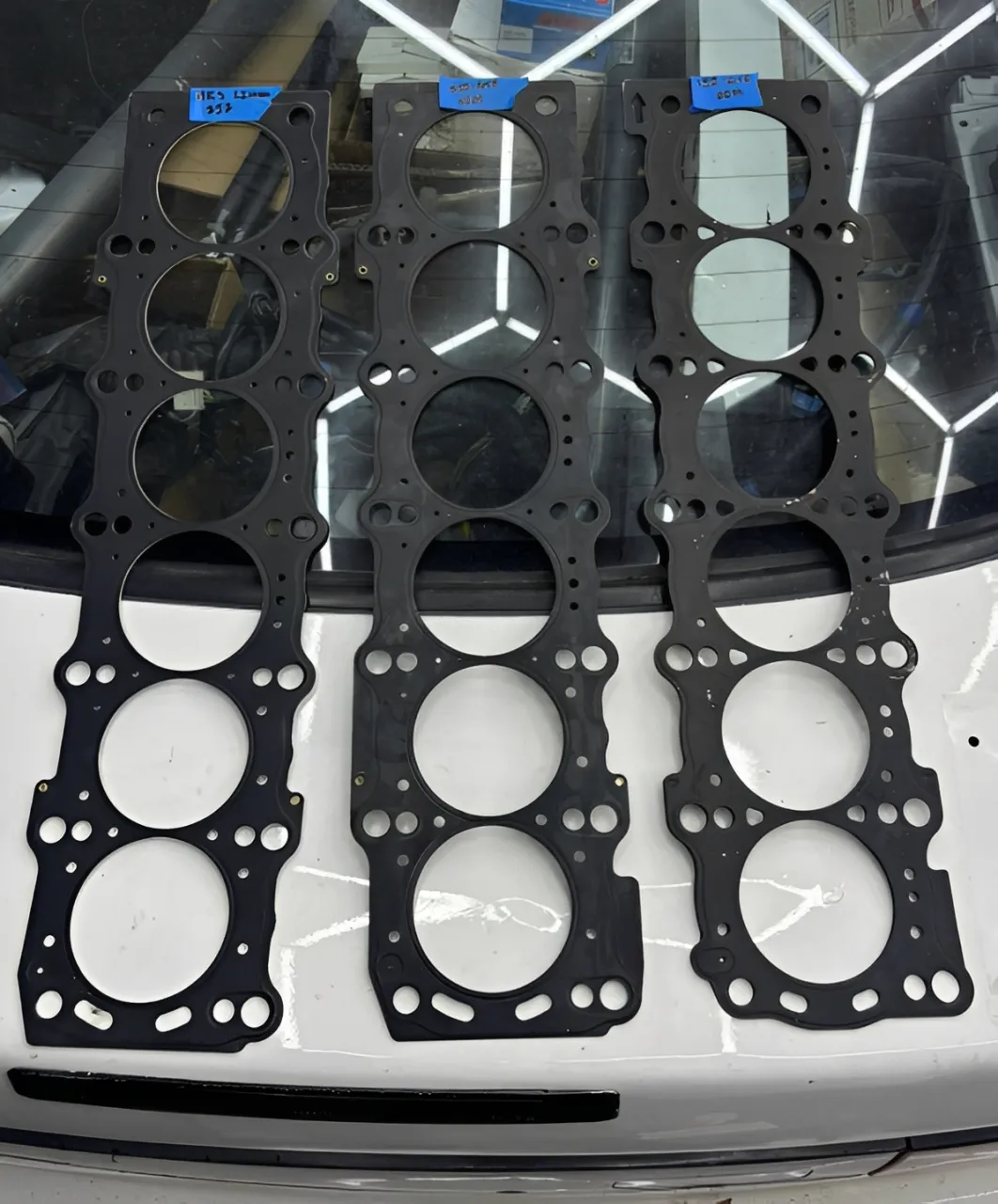 Split-screen comparison image: A standard OEM gasket next to a premium, FKM-coated MLS upgrade gasket from VP GASKET