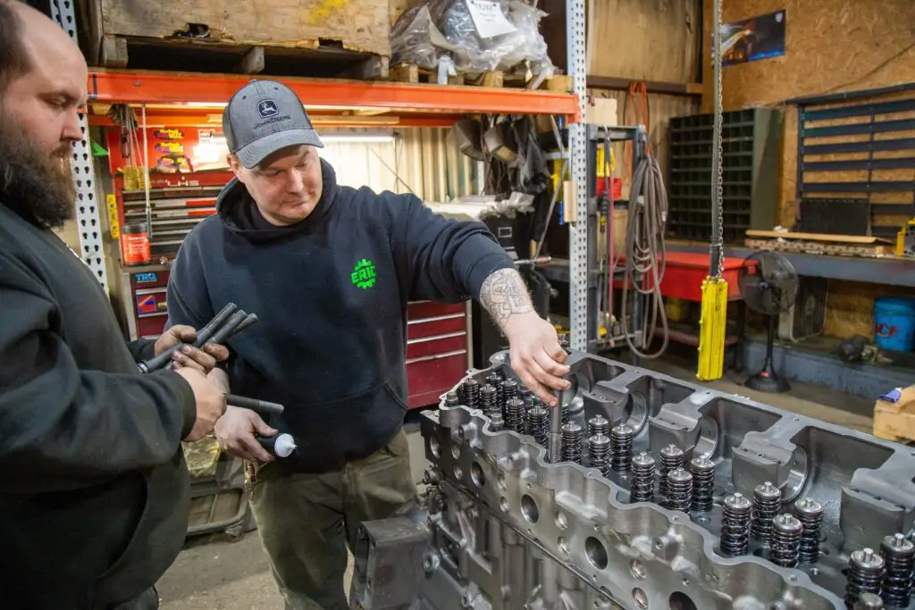 Heavy-duty diesel engine overhaul process on mechanic stand with block preparation using premium engine overhaul kit.