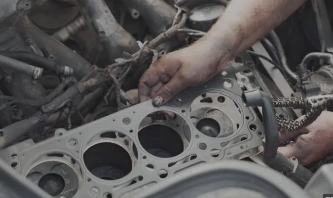 Mechanic installing the best head gasket repair kit for diesel engines.