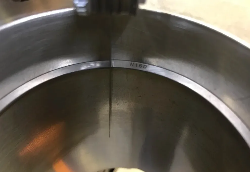 Mechanic measuring piston ring gap with a feeler gauge during a 12 Valve Cummins rebuild.