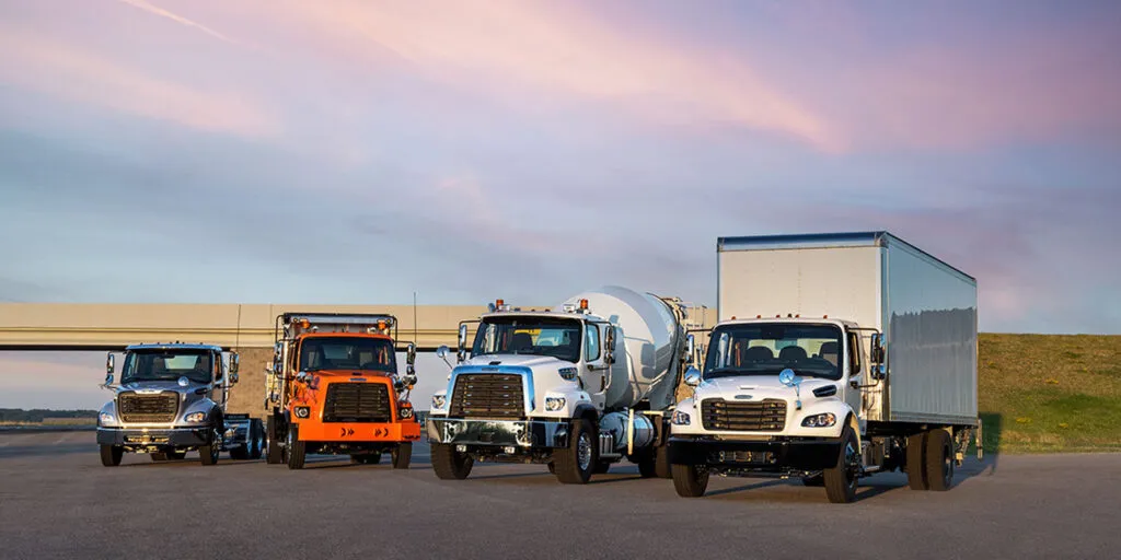 A highway logistics fleet consisting of Freightliner Cascadia and Kenworth T680 trucks demonstrates the real-world applications of heavy-duty commercial trucks.