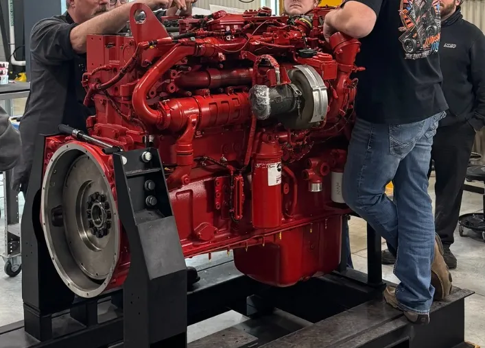A clean Cummins ISX15 engine sitting in a repair shop ready for service