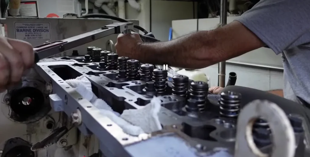 A mechanic checking the cylinder head on a Cummins diesel engine