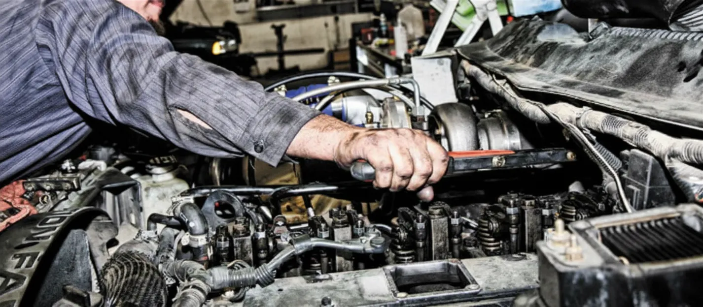 Heavy-duty diesel mechanic inspecting engine manifold