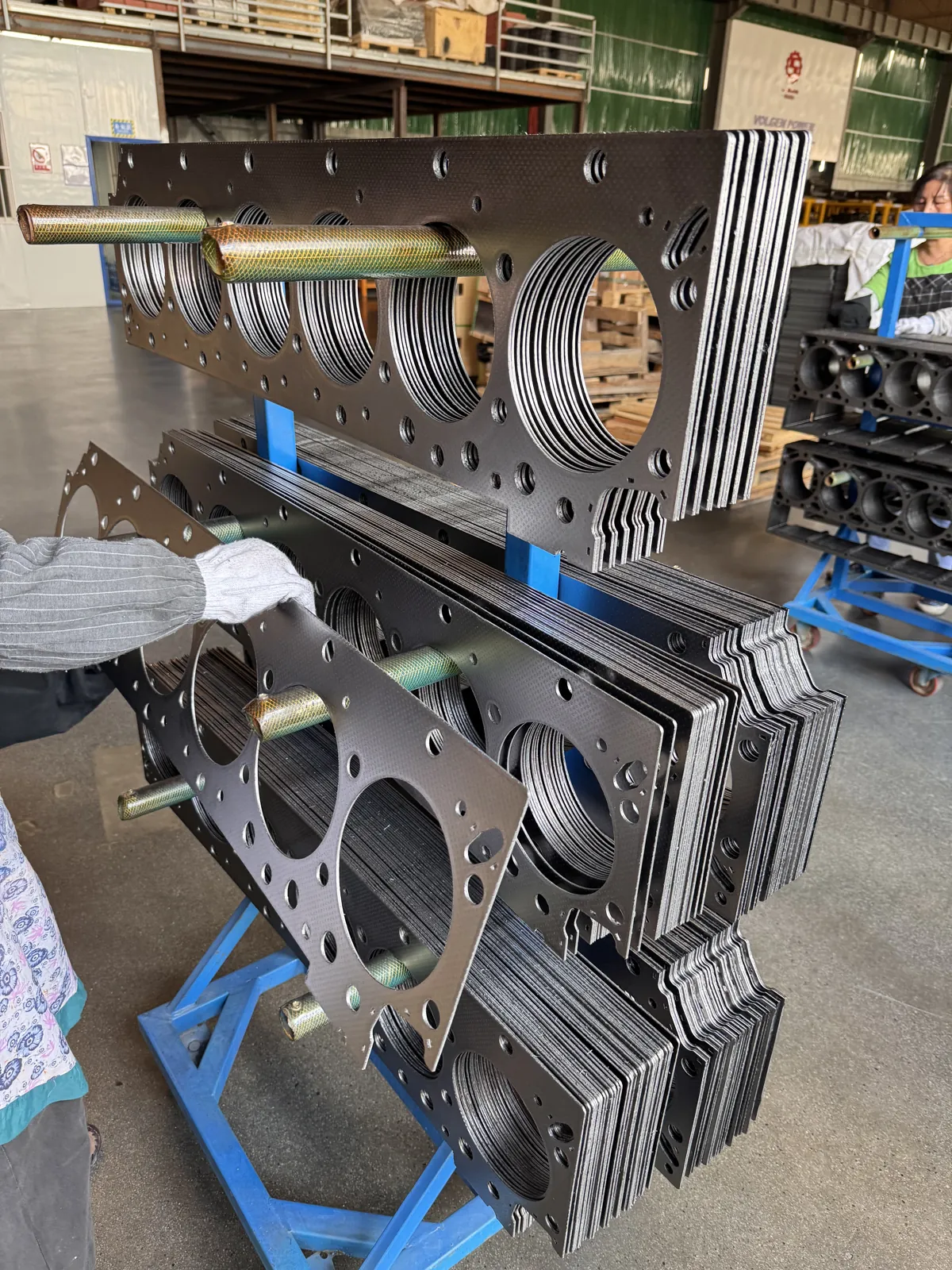 Cylinder head gaskets on a blue workshop rack
