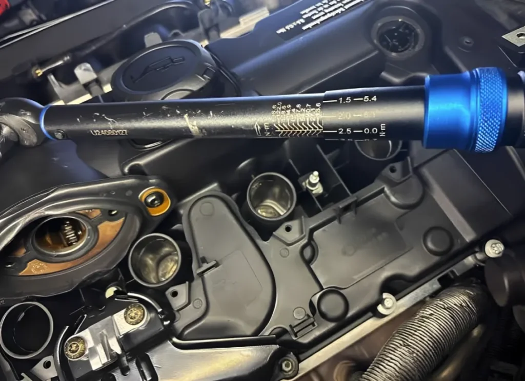 Calibrated torque wrench tightening valve cover fasteners.